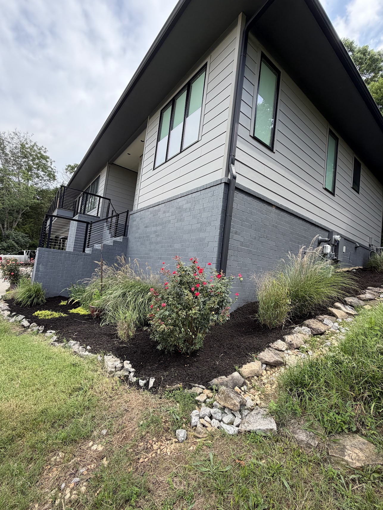 grey house with stairs and lawn